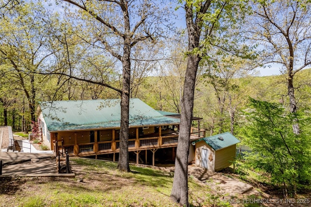 5068 County Road 370, Eucha, OK 74342 - rear view of house featuring metal roof, a shed, a forest view, and an outbuilding