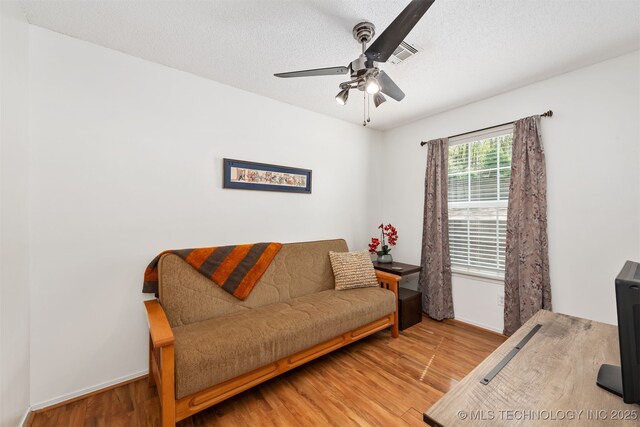 5068 County Road 370, Eucha, OK 74342 - living area with ceiling fan, visible vents, baseboards, a textured ceiling, and wood finished floors