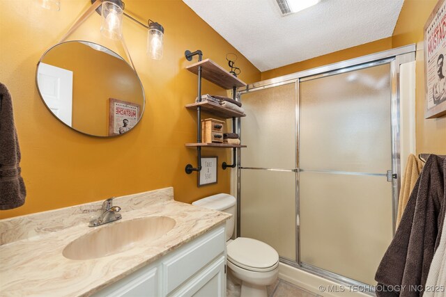 5068 County Road 370, Eucha, OK 74342 - bathroom with vanity, toilet, a stall shower, a textured ceiling, and tile patterned flooring