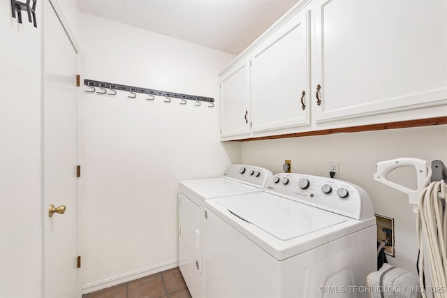 5068 County Road 370, Eucha, OK 74342 - laundry area featuring a textured ceiling, washer and dryer, cabinet space, and tile patterned flooring