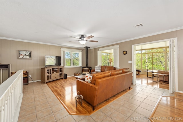 5068 County Road 370, Eucha, OK 74342 - living area with light tile patterned floors, a wood stove, baseboards, ornamental molding, and a ceiling fan