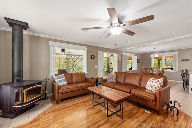 5068 County Road 370, Eucha, OK 74342 - living area with ornamental molding, a wood stove, a ceiling fan, and light wood-style floors