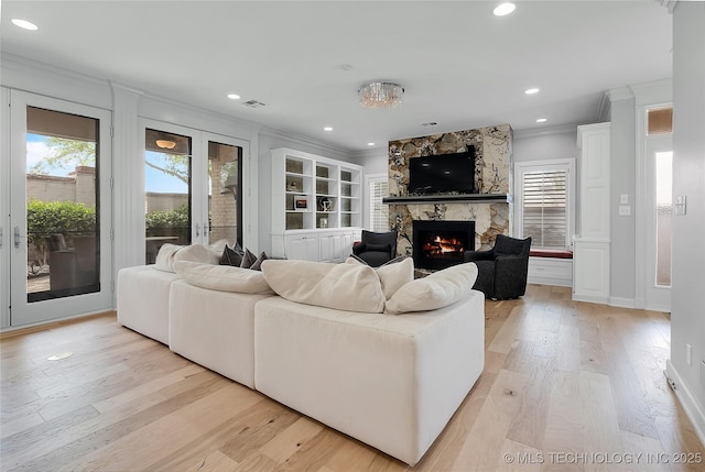 4829 S Zunis Ave, Tulsa, OK 74105 - living room featuring visible vents, ornamental molding, light wood-style floors, and a fireplace