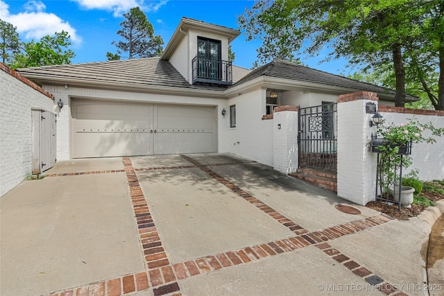 4829 S Zunis Ave, Tulsa, OK 74105 - view of front of house with a tile roof, a balcony, a gate, driveway, and fence