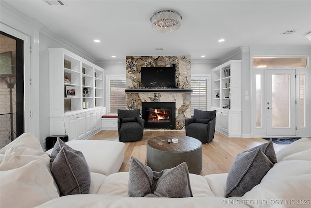 4829 S Zunis Ave, Tulsa, OK 74105 - living room featuring ornamental molding, visible vents, light wood-style flooring, and a stone fireplace
