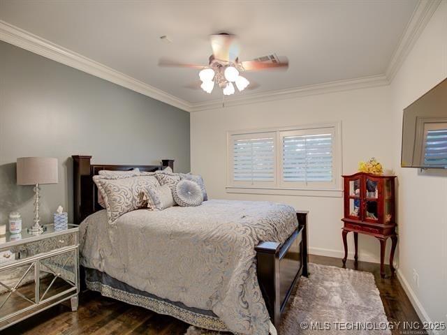 4829 S Zunis Ave, Tulsa, OK 74105 - bedroom with baseboards, ornamental molding, ceiling fan, and dark wood-type flooring