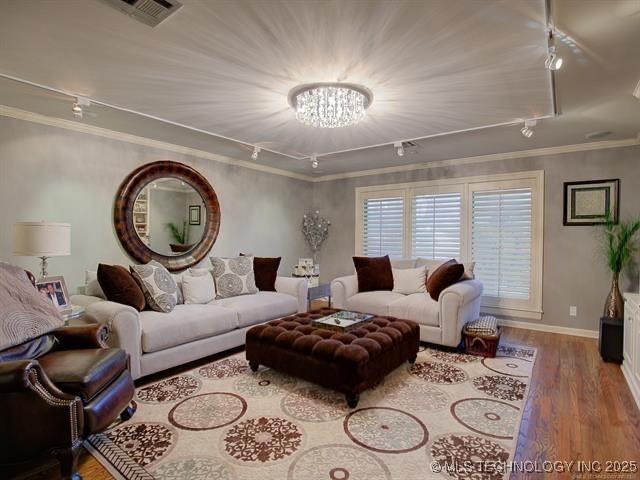 4829 S Zunis Ave, Tulsa, OK 74105 - living room with crown molding, rail lighting, wood finished floors, and baseboards