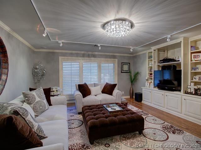 4829 S Zunis Ave, Tulsa, OK 74105 - living area featuring track lighting, a chandelier, light wood-type flooring, and crown molding