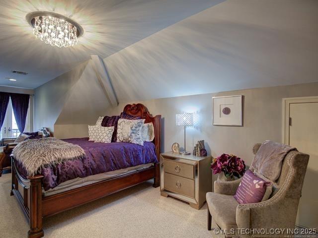 4829 S Zunis Ave, Tulsa, OK 74105 - bedroom with a chandelier, visible vents, light carpet, and vaulted ceiling