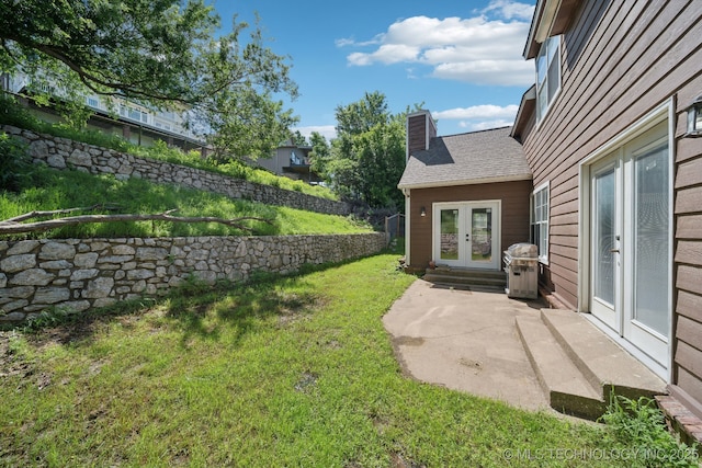 view of yard featuring french doors, fence, and a patio