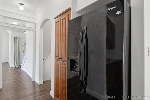 hallway featuring baseboards, ornamental molding, dark wood finished floors, and arched walkways