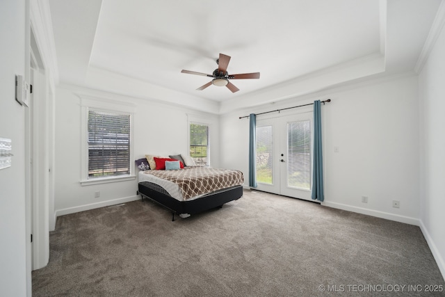 carpeted bedroom featuring baseboards, a tray ceiling, access to exterior, and french doors