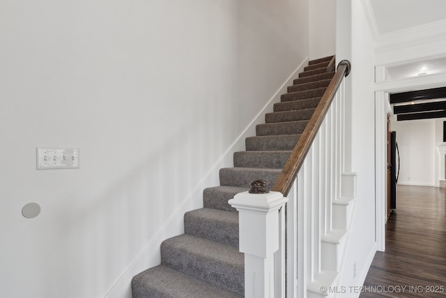 staircase featuring baseboards, ornamental molding, and wood finished floors