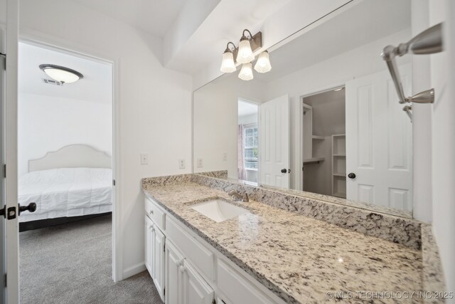 ensuite bathroom featuring vanity, ensuite bath, a chandelier, and visible vents