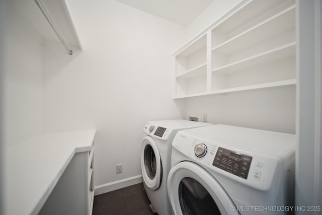washroom with laundry area, baseboards, independent washer and dryer, and dark tile patterned floors