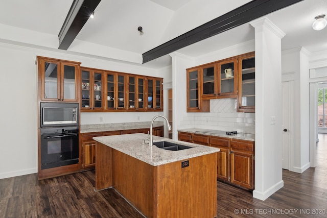 kitchen with brown cabinets, glass insert cabinets, a sink, and black appliances