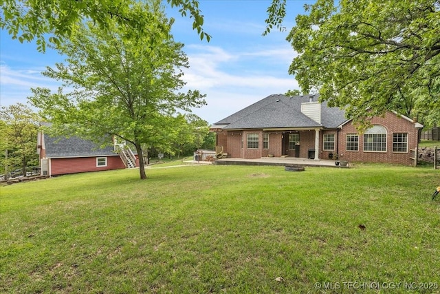 13215 E 182nd Cir, Bixby, OK 74008 - back of house featuring a patio, a lawn, brick siding, and a chimney
