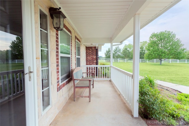 view of patio / terrace featuring fence and a porch