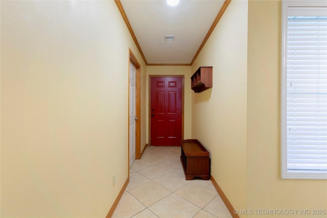 corridor with baseboards, visible vents, ornamental molding, and light tile patterned floors