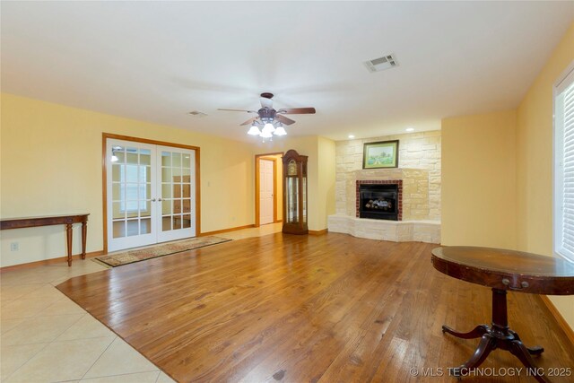 2284 E Roping Rd, Atoka, OK 74525 - unfurnished living room with a ceiling fan, french doors, a fireplace, and wood finished floors