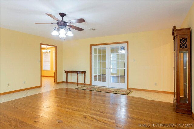 2284 E Roping Rd, Atoka, OK 74525 - spare room with french doors, ceiling fan, baseboards, a chandelier, and wood finished floors