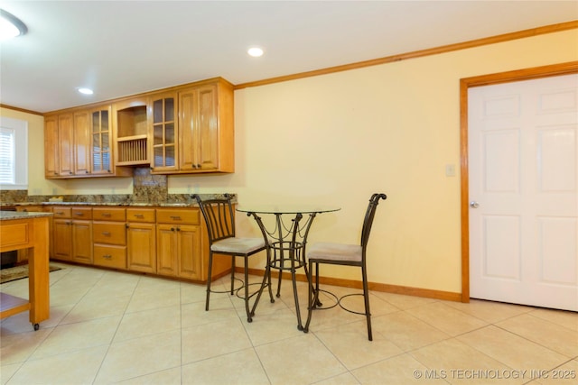 kitchen with ornamental molding, recessed lighting, brown cabinets, and glass insert cabinets