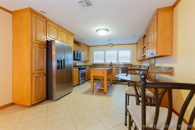 kitchen with appliances with stainless steel finishes, visible vents, and brown cabinets