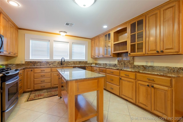 kitchen with visible vents, stainless steel appliances, brown cabinets, and light stone counters