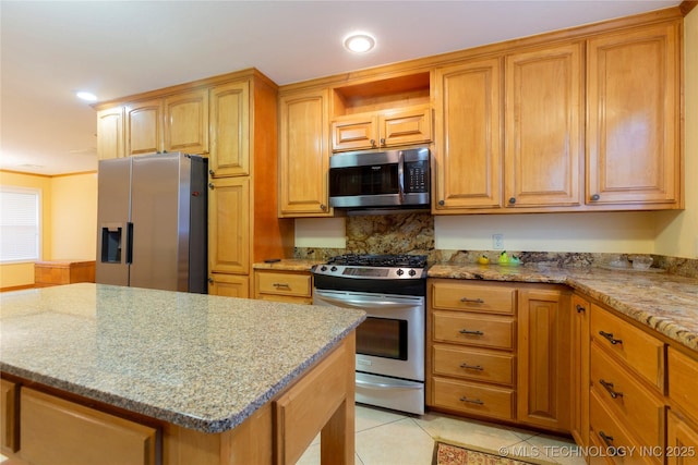 kitchen with light stone counters, stainless steel appliances, a center island, light tile patterned flooring, and recessed lighting