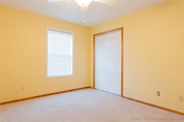 2284 E Roping Rd, Atoka, OK 74525 - unfurnished bedroom featuring light colored carpet, a closet, and a ceiling fan