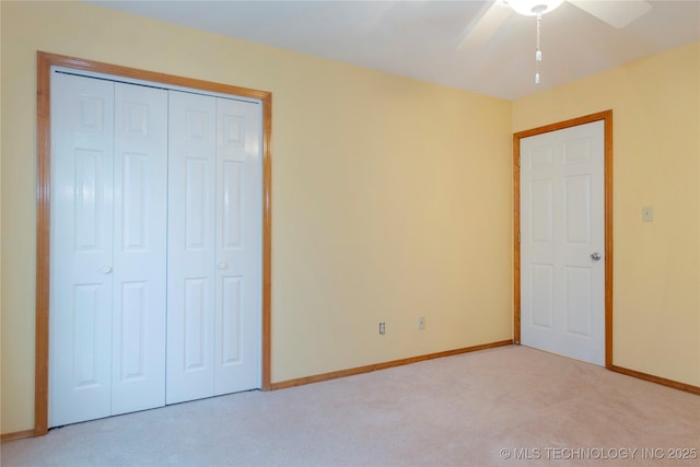 unfurnished bedroom with ceiling fan, baseboards, carpet flooring, and a closet
