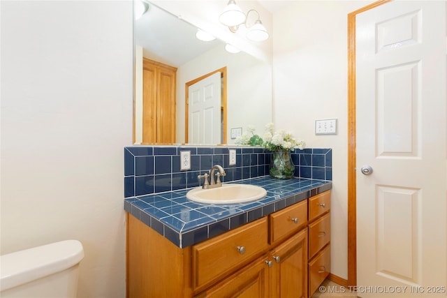 bathroom with toilet, backsplash, and vanity