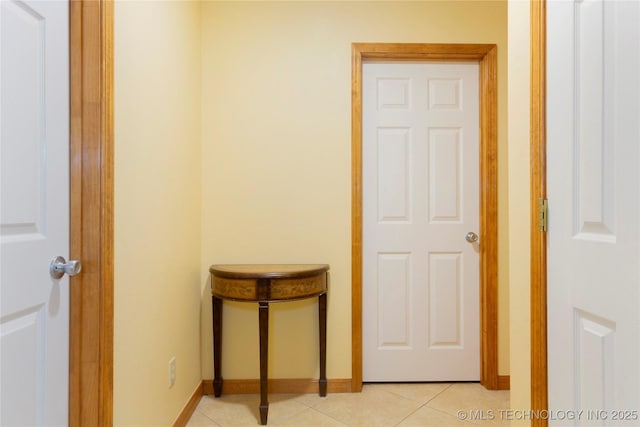 hall featuring baseboards and light tile patterned flooring