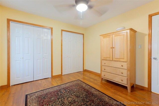 2284 E Roping Rd, Atoka, OK 74525 - bedroom featuring light wood-style flooring, two closets, and a ceiling fan