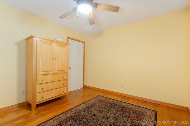 bedroom with baseboards, a ceiling fan, and light wood-style floors