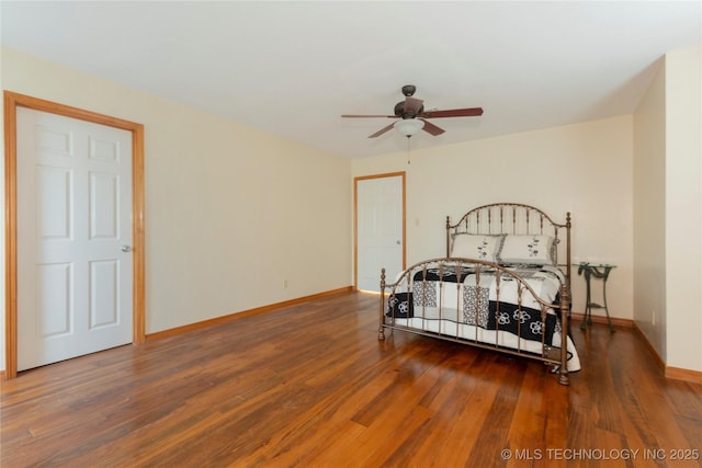 bedroom with ceiling fan, wood finished floors, and baseboards