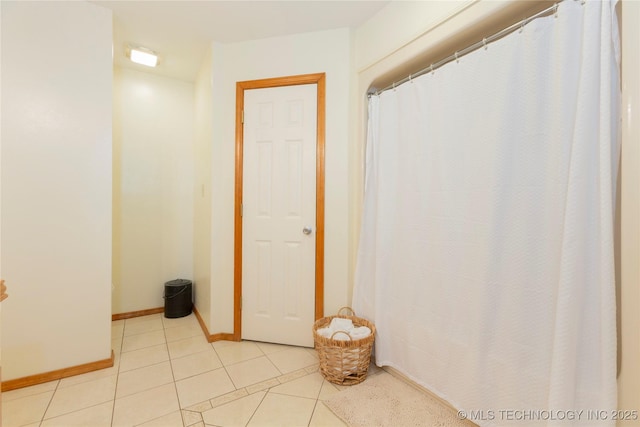 interior space with baseboards and tile patterned flooring