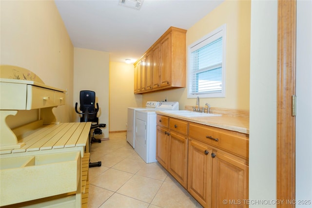 laundry area featuring a sink, cabinet space, light tile patterned flooring, visible vents, and washer and dryer