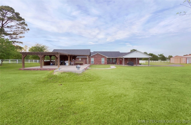 back of house featuring an outdoor structure, a patio, a gazebo, a lawn, and fence