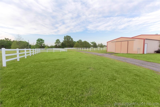 view of yard featuring fence, an outdoor structure, and an outbuilding