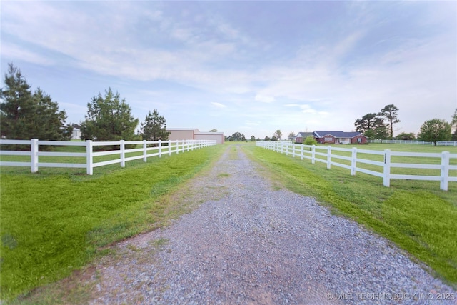 view of road with a rural view and gravel driveway