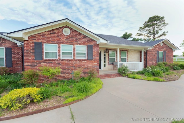 ranch-style house featuring brick siding and a porch