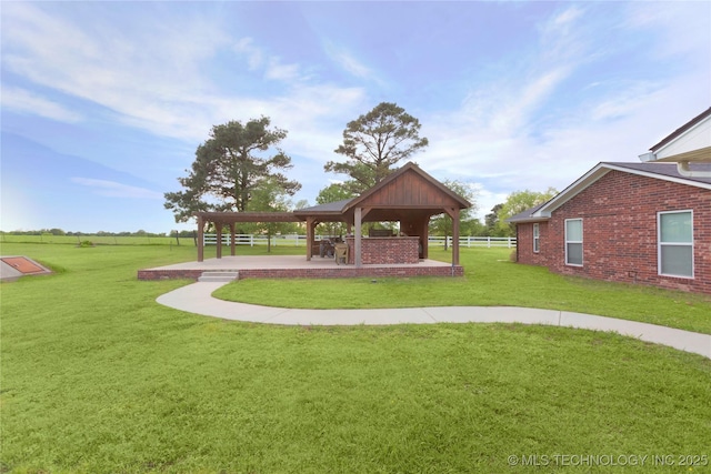 view of property's community featuring a yard, a gazebo, and fence