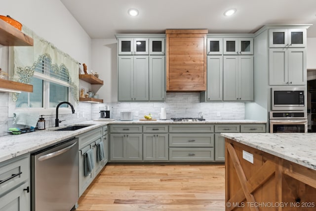 9218 N 141st E Ave, Owasso, OK 74055 - kitchen featuring open shelves, a sink, light wood-style floors, stainless steel appliances, and backsplash