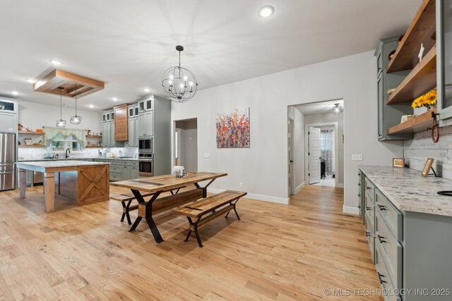 9218 N 141st E Ave, Owasso, OK 74055 - kitchen with stainless steel appliances, open shelves, backsplash, baseboards, and light wood-type flooring