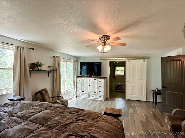 9585 Celia Berryhill Rd, Okmulgee, OK 74447 - bedroom with a textured ceiling, wood finished floors, and a ceiling fan