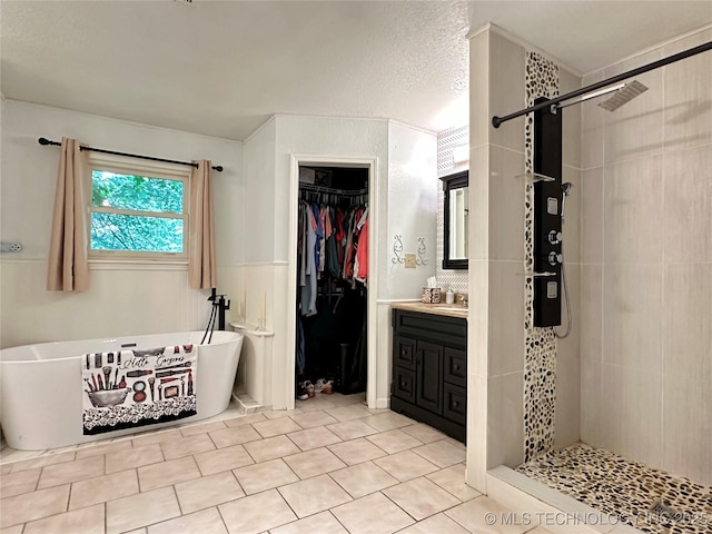 9585 Celia Berryhill Rd, Okmulgee, OK 74447 - full bath with a stall shower, vanity, a freestanding tub, a spacious closet, and tile patterned floors