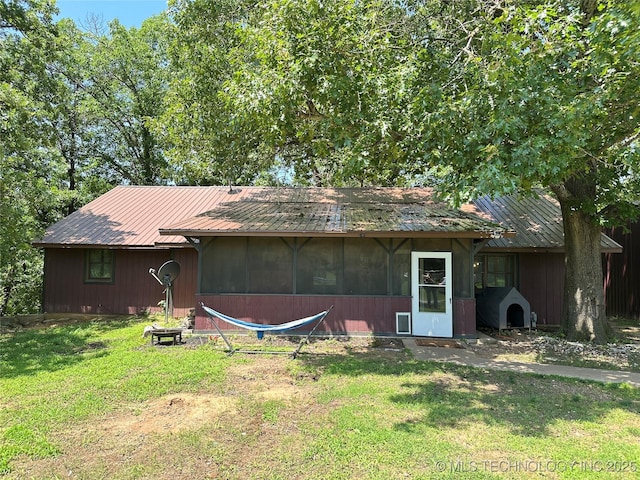 9585 Celia Berryhill Rd, Okmulgee, OK 74447 - back of house featuring a lawn, a metal roof, and a sunroom