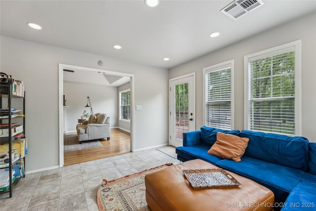 tiled living room featuring recessed lighting, visible vents, and baseboards