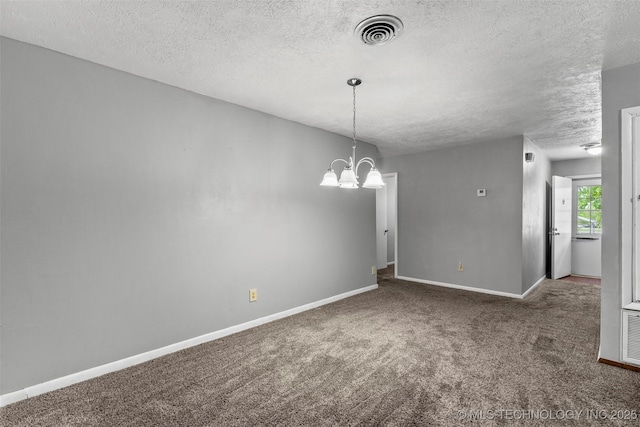 carpeted spare room with a notable chandelier, a textured ceiling, visible vents, and baseboards